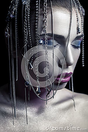Different style of beauty. young beautiful fashion model with silver, purple, blue makeup and shiny silver jewelry chain on her fa Stock Photo