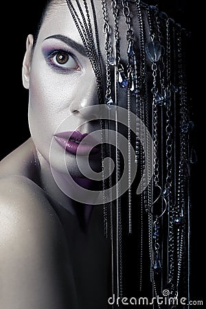 Different style of beauty. young beautiful fashion model with silver, purple, blue makeup and shiny silver jewelry chain on her fa Stock Photo