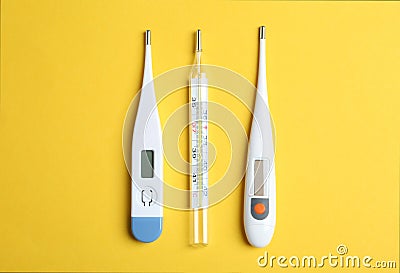 Different thermometers on yellow background Stock Photo