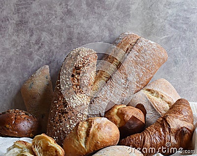 Different types of baking still life. Buns croissants, muffins and loaves, bread patties on textile drapery. Rustic Stock Photo