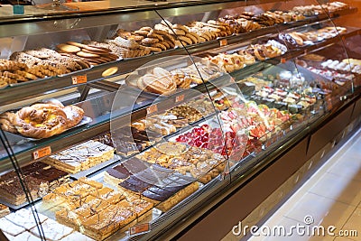 Different types of delicious cakes in pastry shop showcase. Stock Photo