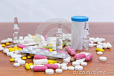 Different types of drugs are scattered on the table. Treatment of diseases with modern methods. Homeopathic and chemicals. Stock Photo