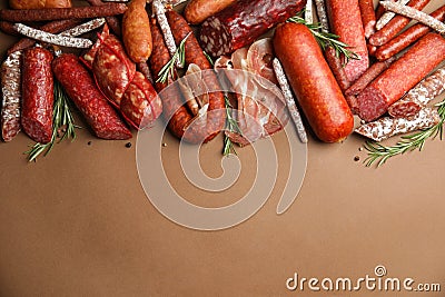 Different types of sausages with rosemary on brown background, flat lay. Space for text Stock Photo