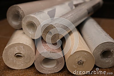 Different wall paper rolls on floor indoors, closeup Stock Photo