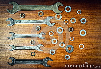 Different wrenches, nuts and washers on a brown wood texture background Stock Photo