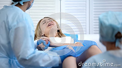 Difficult child birth process, obstetricians supporting female, natural labour Stock Photo
