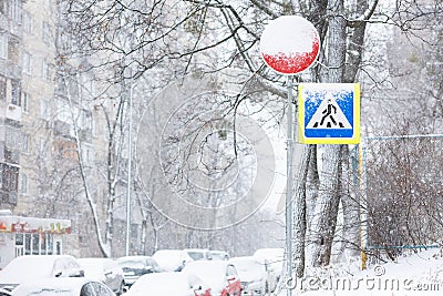 difficult road conditions - road in the winter snowfall with pedestrian crossing sign Stock Photo