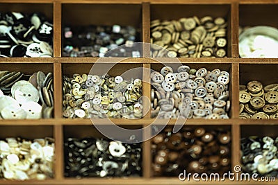 Diffrent multicolored buttons in wooden boxes for creativity, a real store shelf, selective background. Textile industry Stock Photo