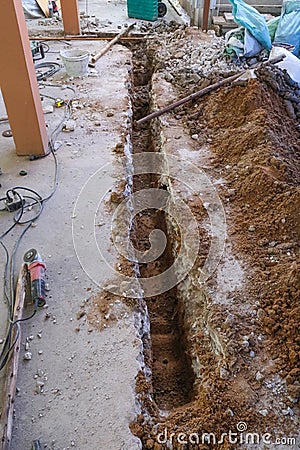 dig long hole line on concrete prepare for make foundation building room. renavation house dirty job landscape Stock Photo