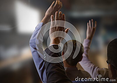 Business people with hands raised up at conference Stock Photo