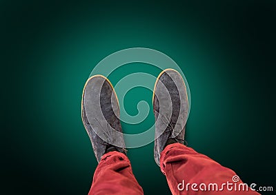 Grey shoes on feet with green background Stock Photo