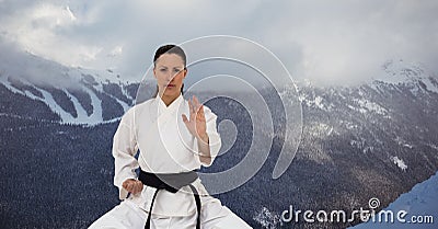Digital composite image of caucasian female marital artist with black belt against winter landscape Stock Photo