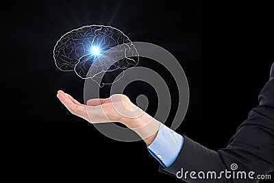 Digital composite image of hand holding human brain graphics against black background Stock Photo