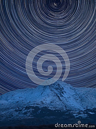 Digital composite image of star trails around Polaris with landscape of Mount Snowdon Stock Photo