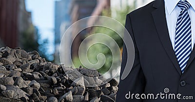 Ruibble stones in pile with businessman in city Stock Photo