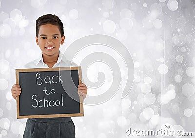 Schoolboy holding back to school blackboard in front of bright bokeh background Stock Photo