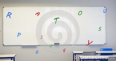 Digital composition of multiple colorful alphabets floating against white board in empty classroom Stock Photo