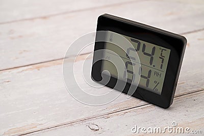 Digital indoor temperature and humidity monitor in a summer on a wooden table Stock Photo