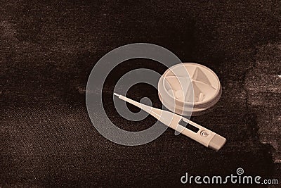 Digital medical thermometer and white pills Stock Photo