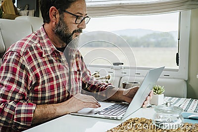 Digital nomad fulltimer traveler people using computer inside a motorhome van. Modern small business online man working on laptop Stock Photo