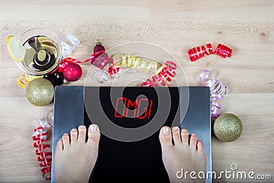 Digital scales with female feet on them and sign `omg!` surrounded by Christmas decorations Stock Photo