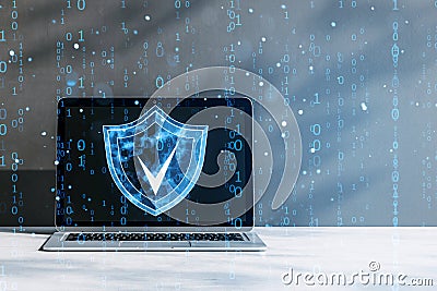 Digital shield icon on laptop screen with binary code overlay representing cybersecurity on a gray background Stock Photo
