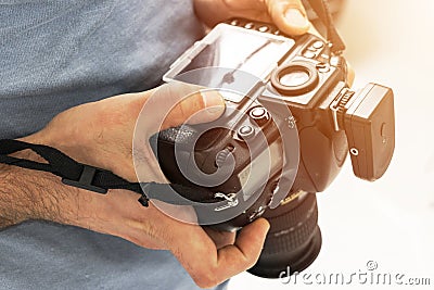 Digital single lens reflex camera in male hands. Photographer shooting hands close up. Man photographer makes photos. Male hands h Stock Photo