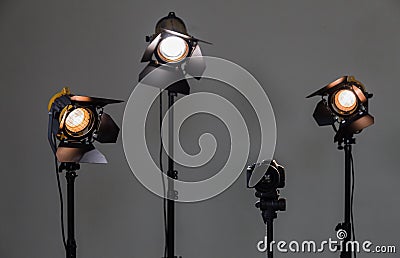 Digital SLR camera and three spotlights with Fresnel lenses. Manual interchangeable lens for filming Stock Photo