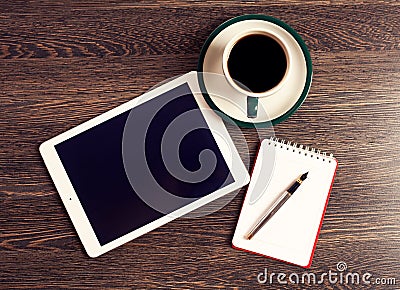 Digital tablet computer with note paper and cup of coffee on old wooden desk Stock Photo