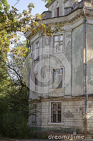 Dilapidated facade of an old building in an autumn park Stock Photo