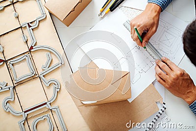 Diligent box designer making a sketch on paper. Hands only,no face Stock Photo