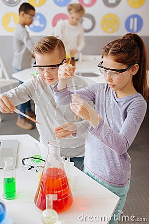 Diligent classmates adding chemicals to sample tubes Stock Photo