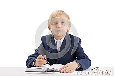 Diligent schoolboy sits at a desk with a pen and listens attentively to the teacher. First grader in class. Education concept Stock Photo