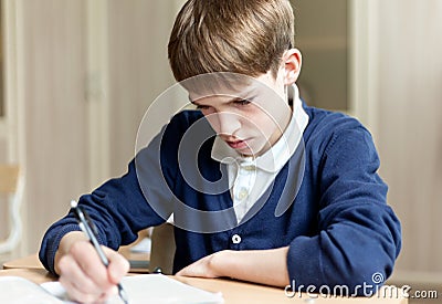 Diligent student sitting at desk, classroom Stock Photo