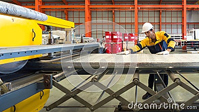 A diligent worker is engrossed in his task, carefully manipulating a vast sheet of metal, the gleam of effort and precision Stock Photo