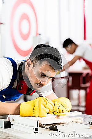 Diligent worker in factory working on wood Stock Photo