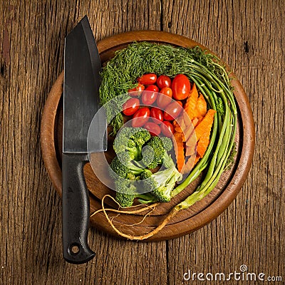 dill. baby tomatoes. carrot. broccoli. knife. on old chopping bo Stock Photo