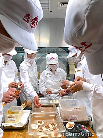 Chefs are cooking Chinese dumplings by the traditional bamboo steamers in a restaurant. Editorial Stock Photo