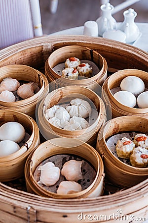 Dim sum set: Barbecued pork bun, Shrimp dumpling, Sweet cream buns, Shrimp shumai topping with goji berry served in steamer basket Stock Photo