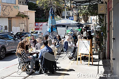 Diners enjoy their meals at a cafe adjacent to the bustling Talpiot market Editorial Stock Photo