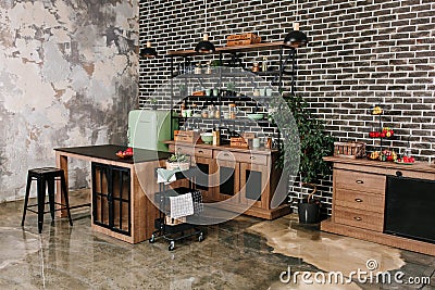 Dining area in industrial style with table, chairs and mint retro fridge. Black vintage brick wall background Stock Photo