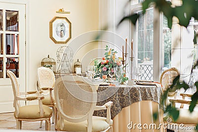 A dining table and comfortable armchairs in a modern house with a light dining room Editorial Stock Photo