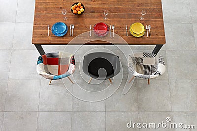 Dining wooden table and color porcelain plates Stock Photo