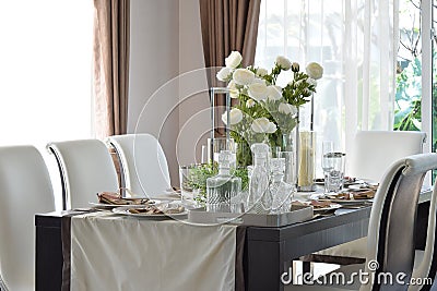Dining wooden table and comfortable chairs in modern home Stock Photo