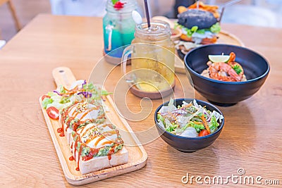 Dinner in cafe with eggs benedict, toast with avocado, pasta with shrimps and drinks Stock Photo