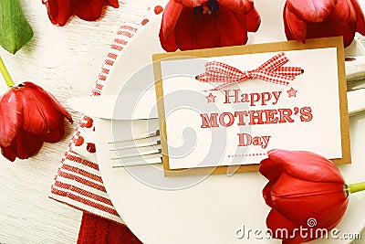 Dinner table setting with Mothers day message card and tulips Stock Photo