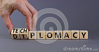Diplomacy or techplomacy symbol. Businessman turns cubes and changes the concept word diplomacy to techplomacy. Beautiful grey Stock Photo