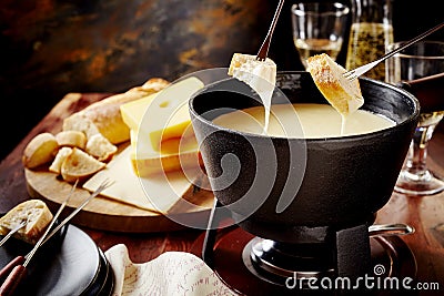 Dipping into a delicious cheese fondue Stock Photo