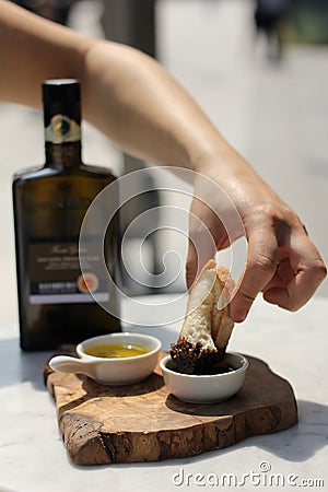 Dipping Fresh Italian Bread into Balsamic Vinegar Stock Photo