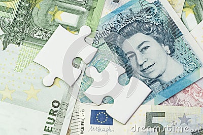 Direction of Europe and UK after Brexit negotiation concept, jigsaw puzzle metaphor on Euro and UK Pound banknotes Editorial Stock Photo